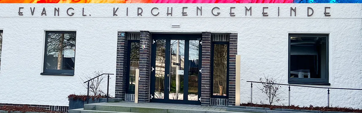 Eingang einer Evangelischen Kirchengemeinde mit bunten Streifen darüber.