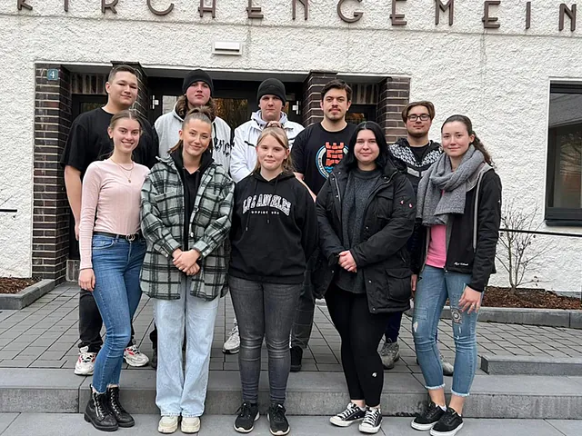 Junge Gruppe vor Kirchengebäude.