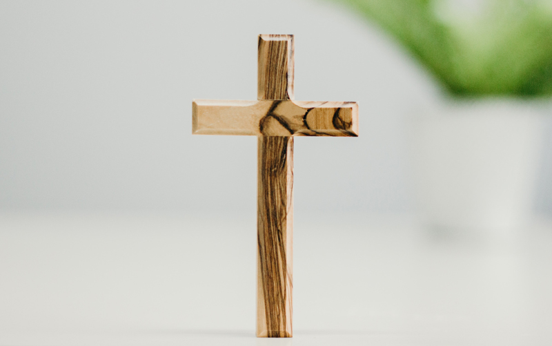 Holzkreuz auf weißem Hintergrund.