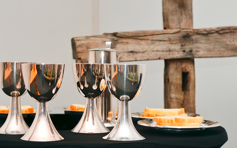 Kelche und Holzkreuz.